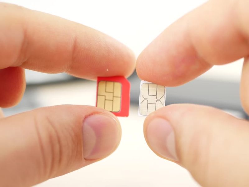 Osoba drži dve kartice za telefon u rukama
