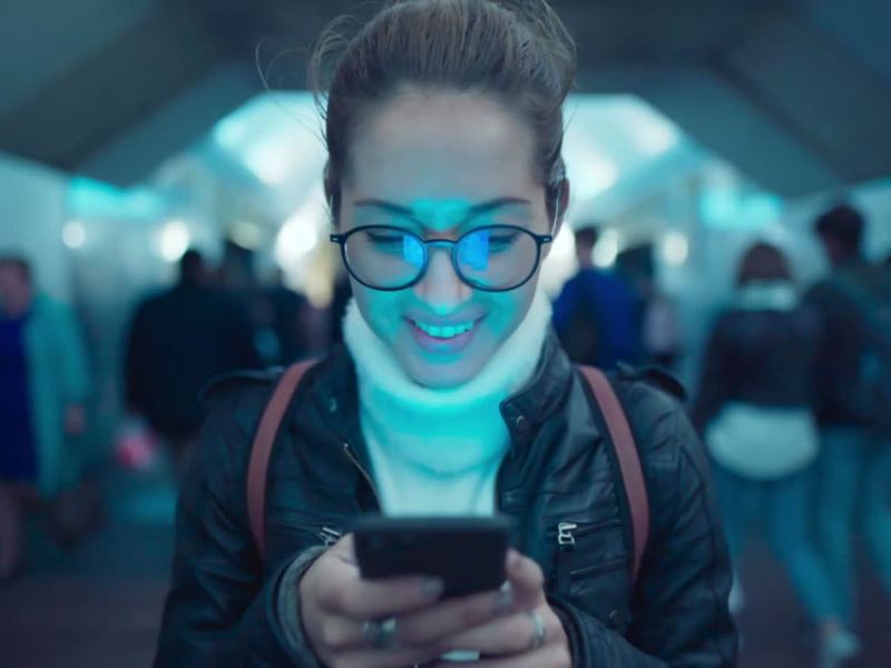 Devojka sa naočarima u tunelu koristi mobilni telefon