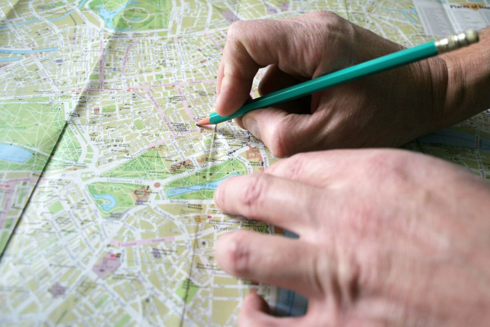 Planiranje rute na papirnoj mapi pre putovanja automobilom