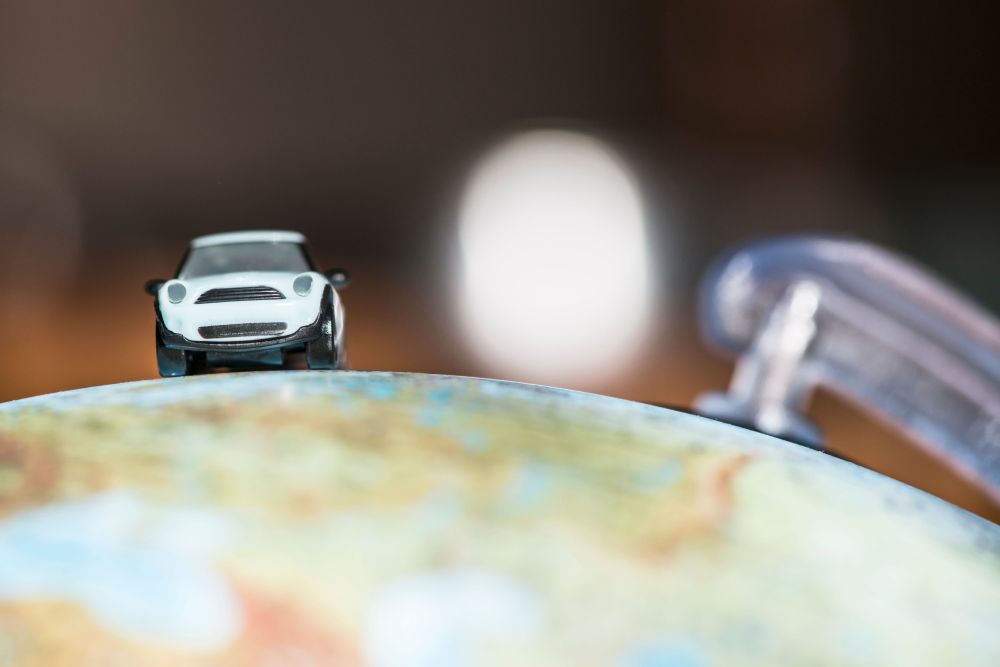 Igračka automobil na globusu kao simbol putovanja kolima