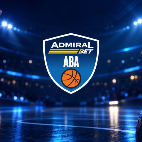 Logo AdmiralBet ABA lige u centru osvetljene košarkaške arene, sa košem u gornjem levom uglu i košarkaškom loptom u prvom planu